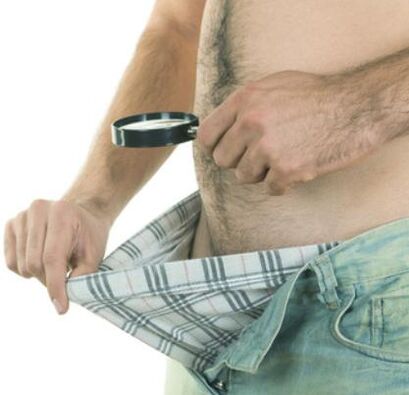 moški pregleda svoj penis in ga želi povečati